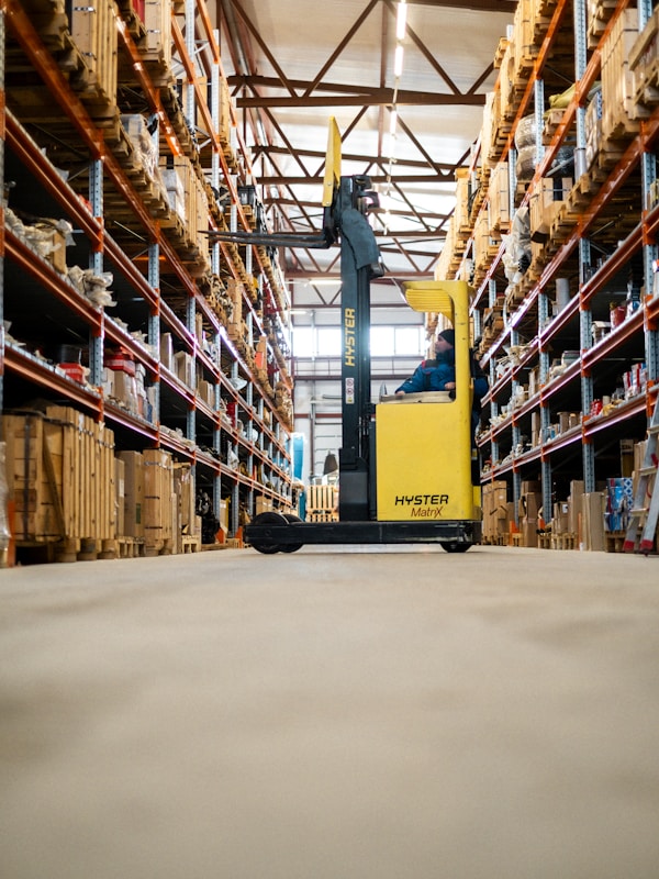 Forklift moving pallets in a warehouse aisle